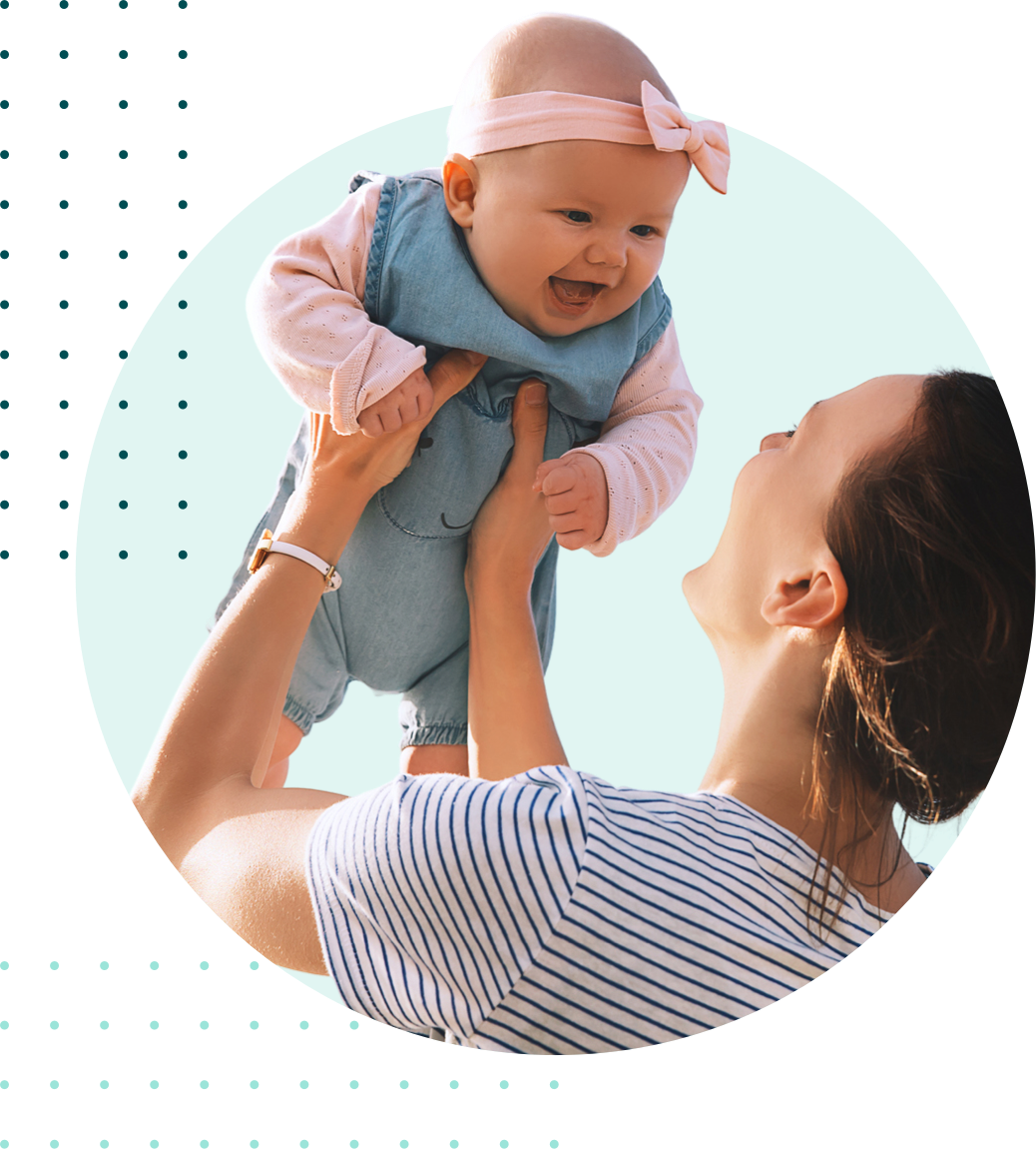 Smiling woman holding her laughing baby up over her head