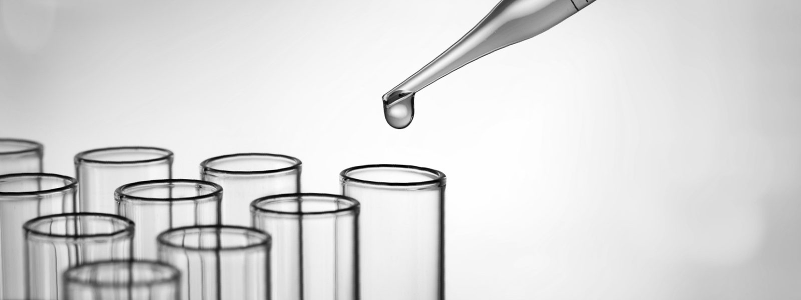 Dropper adding fluid to lab vials